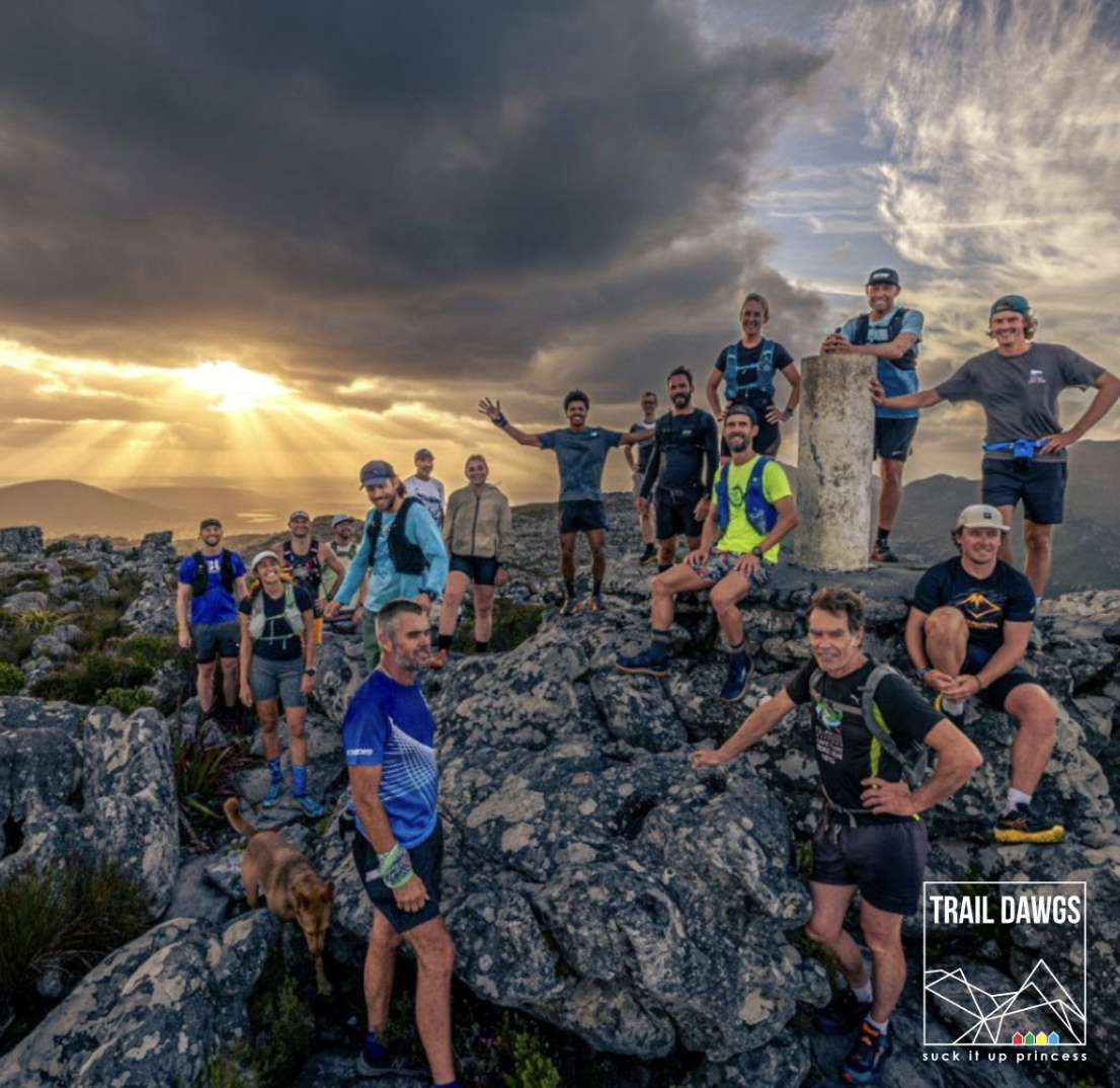 Trail Dawgs group photo at sunset on rocky terrain
